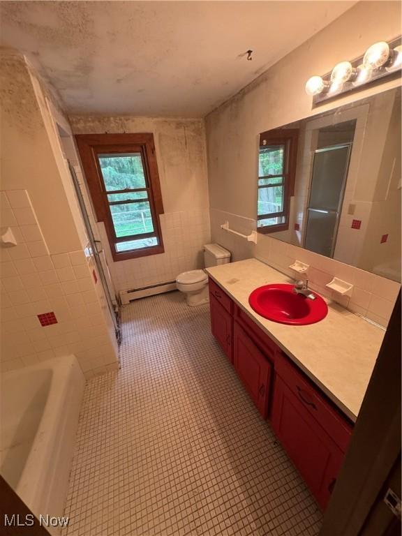 9999 Kirtland Chardon Rd, Chardon, OH 44024 - full bath with vanity, a shower stall, a baseboard heating unit, a tub to relax in, and tile patterned floors
