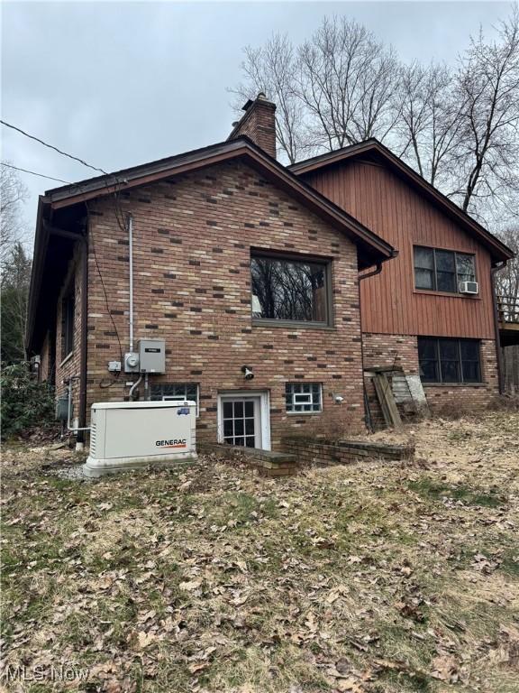 9999 Kirtland Chardon Rd, Chardon, OH 44024 - view of home's exterior featuring brick siding, a chimney, and cooling unit