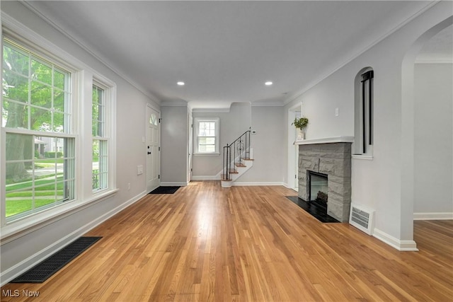 17631 Milburn Ave, Cleveland, OH 44135 - entryway featuring light wood-type flooring, ornamental molding, stairway, a stone fireplace, and arched walkways