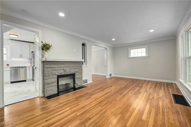 17631 Milburn Ave, Cleveland, OH 44135 - unfurnished living room featuring ornamental molding, arched walkways, light wood-style flooring, a fireplace, and recessed lighting