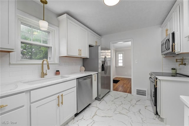 17631 Milburn Ave, Cleveland, OH 44135 - kitchen featuring appliances with stainless steel finishes, light marble finish floors, white cabinets, and decorative backsplash