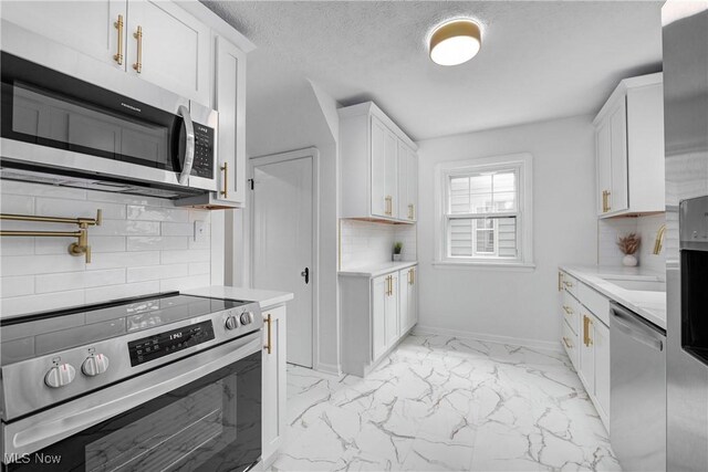 17631 Milburn Ave, Cleveland, OH 44135 - kitchen with stainless steel appliances, light marble finish floors, tasteful backsplash, light countertops, and white cabinets