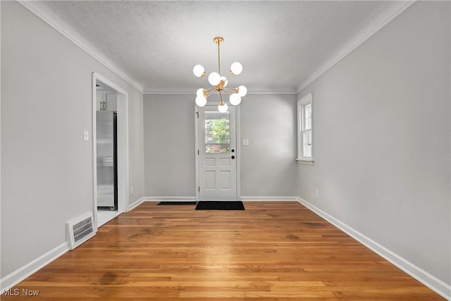 17631 Milburn Ave, Cleveland, OH 44135 - foyer featuring a chandelier, crown molding, light wood finished floors, and a textured ceiling