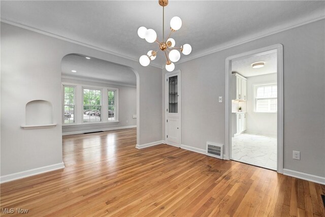 17631 Milburn Ave, Cleveland, OH 44135 - unfurnished room featuring arched walkways, light wood-type flooring, plenty of natural light, crown molding, and a chandelier
