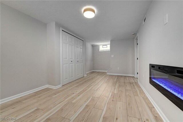 17631 Milburn Ave, Cleveland, OH 44135 - below grade area featuring light wood-type flooring and a textured ceiling