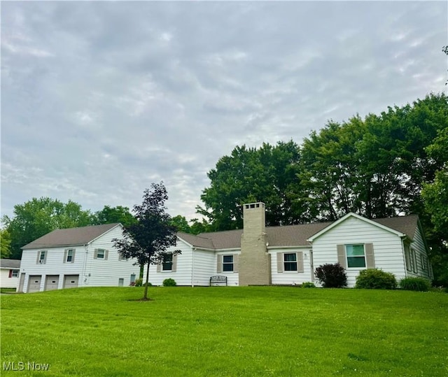 1803 Stillwagon Rd, Warren, OH 44484 - view of front facade with an attached garage, a chimney, and a front lawn
