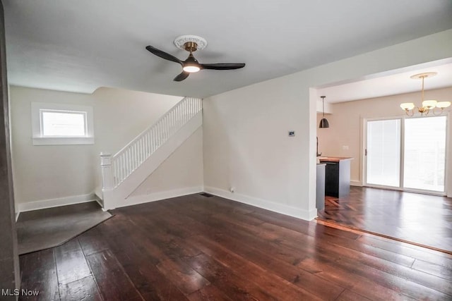 1004 Clarendon Ave SW, Canton, OH 44710 - unfurnished living room featuring dark wood-style floors, a chandelier, stairs, and a ceiling fan
