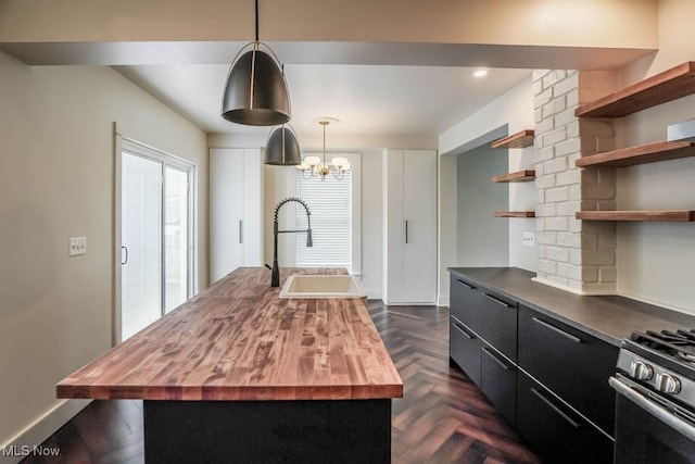 1004 Clarendon Ave SW, Canton, OH 44710 - kitchen featuring butcher block counters, open shelves, an island with sink, a chandelier, and dark cabinets