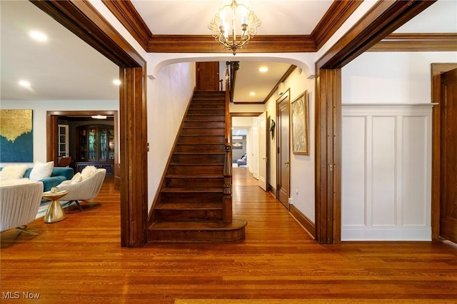 17805 Van Aken Blvd, Shaker Heights, OH 44122 - staircase featuring ornamental molding, wood finished floors, a chandelier, and arched walkways