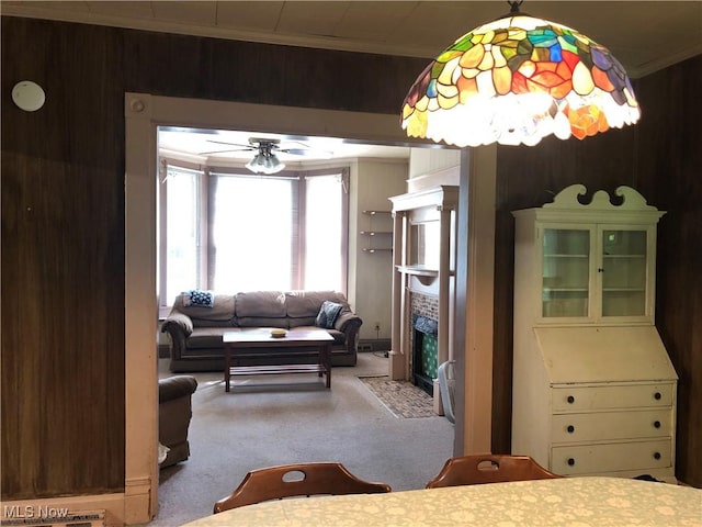 305 Adolphus St, Chester, WV 26034 - living area with carpet, a fireplace with flush hearth, wood walls, a ceiling fan, and crown molding