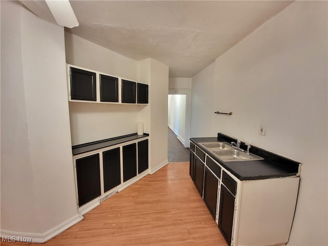 1825 Lakeview Rd, East Cleveland, OH 44112 - kitchen featuring light wood-style flooring, dark countertops, and dark cabinets
