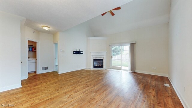 44 Gullybrook Ln, Willoughby, OH 44094 - unfurnished living room with a ceiling fan, light wood-style floors, a tile fireplace, and lofted ceiling