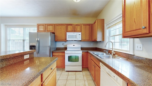 44 Gullybrook Ln, Willoughby, OH 44094 - kitchen featuring white appliances, light tile patterned floors, dark countertops, and brown cabinetry