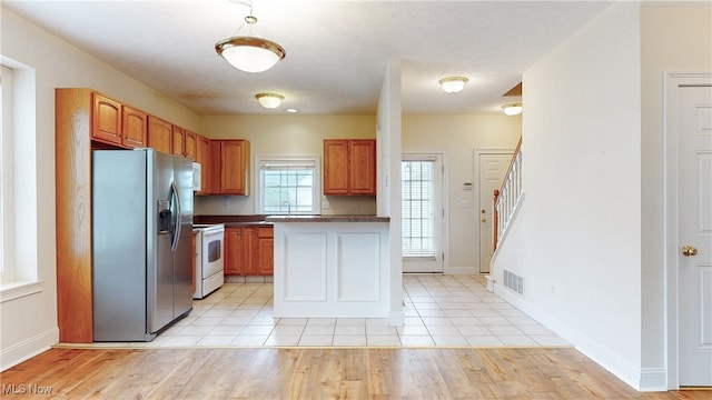 44 Gullybrook Ln, Willoughby, OH 44094 - kitchen featuring white appliances, dark countertops, light tile patterned floors, and brown cabinets