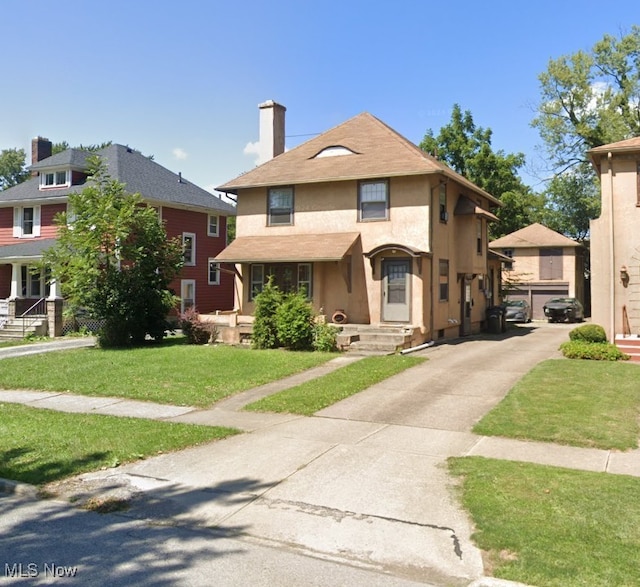 411 9th St, Elyria, OH 44035 - view of front of home featuring stucco siding, a chimney, and a front yard