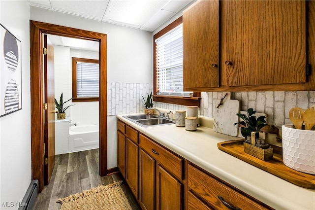 125 N Arlington Ave, Niles, OH 44446 - kitchen with a baseboard radiator, dark wood-style floors, light countertops, backsplash, and brown cabinetry