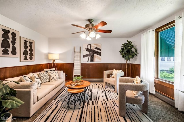 125 N Arlington Ave, Niles, OH 44446 - carpeted living area featuring wainscoting, wood walls, ceiling fan, a textured ceiling, and a baseboard heating unit