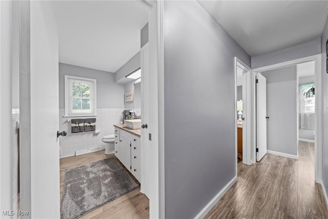 321 Stuart St NW, Lehigh Twp, OH 44646 - corridor with wood finished floors, tile walls, and a wainscoted wall