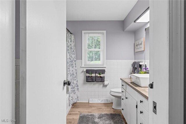 321 Stuart St NW, Lehigh Twp, OH 44646 - full bathroom featuring tile walls, vanity, wainscoting, and wood finished floors