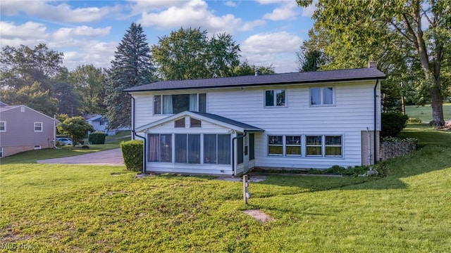 321 Stuart St NW, Lehigh Twp, OH 44646 - back of property with a sunroom, a lawn, and a chimney