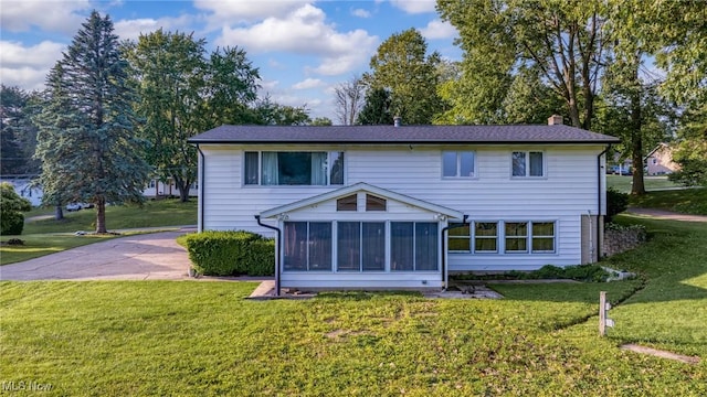 321 Stuart St NW, Lehigh Twp, OH 44646 - back of house featuring a chimney, a sunroom, and a yard