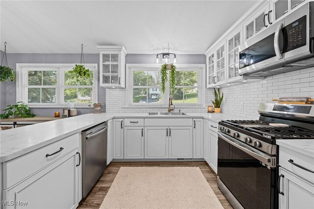 321 Stuart St NW, Lehigh Twp, OH 44646 - kitchen with stainless steel appliances, healthy amount of natural light, decorative backsplash, and light countertops