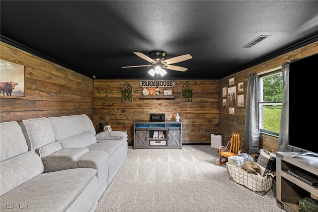 321 Stuart St NW, Lehigh Twp, OH 44646 - living room featuring carpet floors, wood walls, a ceiling fan, ornamental molding, and a textured ceiling
