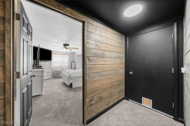 321 Stuart St NW, Lehigh Twp, OH 44646 - foyer entrance featuring carpet flooring, wooden walls, and ceiling fan