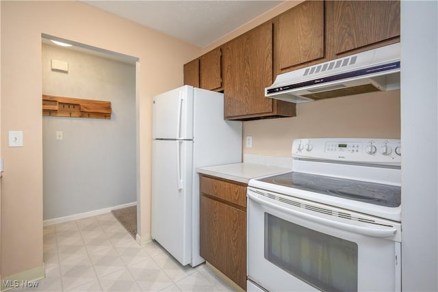 10790 Ravenna Rd Unit 302, Twinsburg, OH 44087 - kitchen featuring white appliances, under cabinet range hood, light floors, light countertops, and brown cabinetry