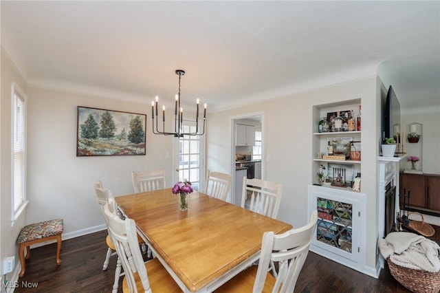 4410 Silsby Rd, University Heights, OH 44118 - dining space featuring a chandelier, dark wood-style flooring, built in features, and a premium fireplace