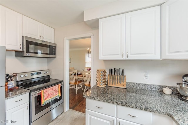 4410 Silsby Rd, University Heights, OH 44118 - kitchen featuring stainless steel appliances, light wood finished floors, white cabinets, and light stone countertops