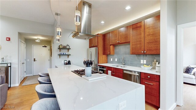 1846 Front St Unit 402, Cuyahoga Falls, OH 44221 - kitchen with island range hood, appliances with stainless steel finishes, decorative backsplash, a kitchen breakfast bar, and light wood-style flooring