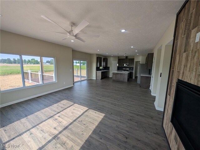41861 State Route 303, Lagrange, OH 44050 - unfurnished living room featuring a ceiling fan, dark wood finished floors, a textured ceiling, a large fireplace, and recessed lighting