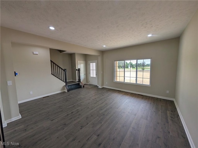 41861 State Route 303, Lagrange, OH 44050 - unfurnished living room featuring a textured ceiling, stairs, dark wood-style flooring, and recessed lighting