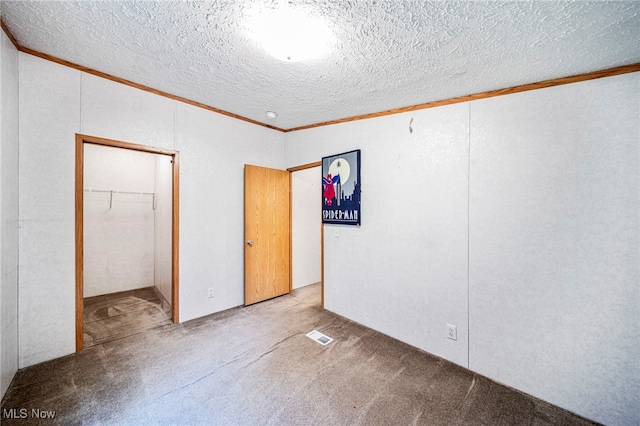6835 Sidley Rd, Thompson, OH 44086 - unfurnished bedroom with ornamental molding, carpet floors, a walk in closet, a closet, and a textured ceiling