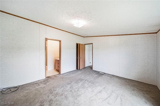 6835 Sidley Rd, Thompson, OH 44086 - unfurnished bedroom with ornamental molding, light carpet, a textured ceiling, and connected bathroom
