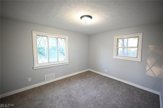 5203 Forest Ave, Maple Heights, OH 44137 - unfurnished room with plenty of natural light, dark colored carpet, and a textured ceiling
