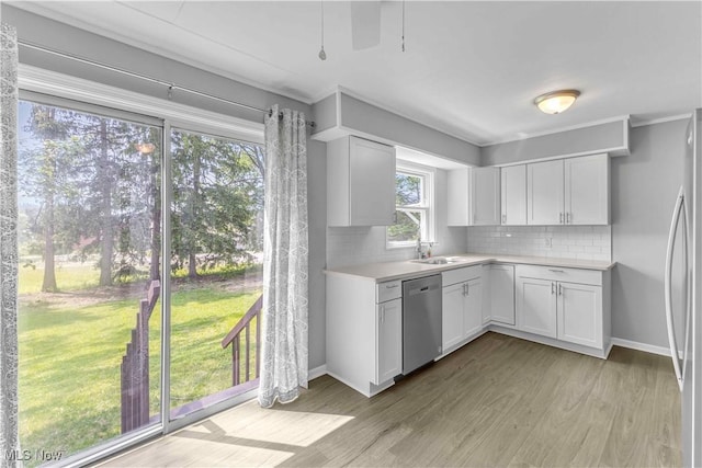 1530 Franklin Ave, Kent, OH 44240 - kitchen featuring appliances with stainless steel finishes, light countertops, light wood-style flooring, decorative backsplash, and white cabinets