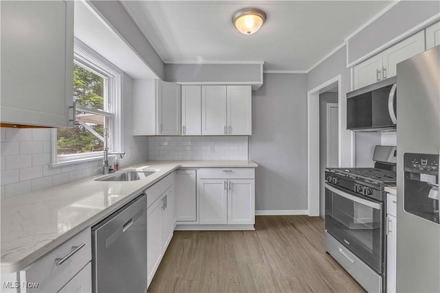 1530 Franklin Ave, Kent, OH 44240 - kitchen with stainless steel appliances, light wood finished floors, white cabinetry, backsplash, and ornamental molding