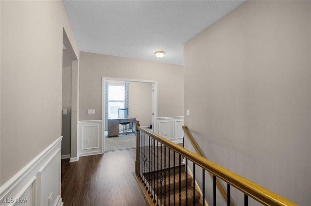 13861 Woodhawk Dr, Strongsville, OH 44136 - hall featuring an upstairs landing, dark wood-style flooring, a wainscoted wall, and a decorative wall
