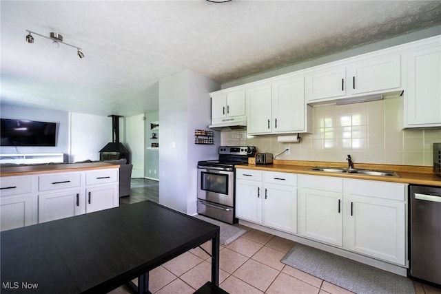 5672 Stanford Ave, Youngstown, OH 44515 - kitchen with appliances with stainless steel finishes, under cabinet range hood, decorative backsplash, and white cabinets