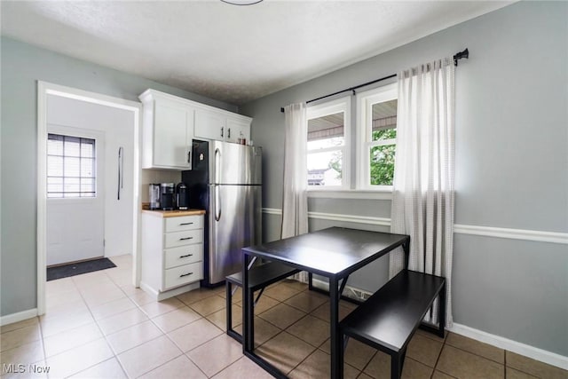 5672 Stanford Ave, Youngstown, OH 44515 - kitchen featuring freestanding refrigerator, healthy amount of natural light, white cabinetry, and light tile patterned floors
