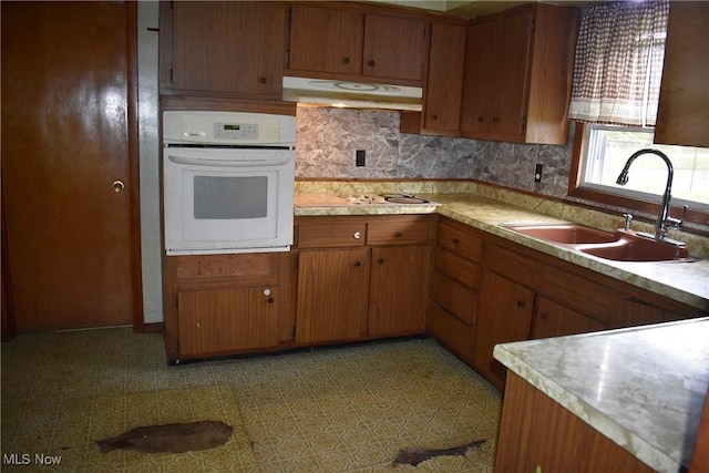 227 Greeley Ln, Youngstown, OH 44505 - kitchen featuring oven, under cabinet range hood, light countertops, and brown cabinetry