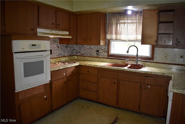 227 Greeley Ln, Youngstown, OH 44505 - kitchen with oven, under cabinet range hood, light countertops, electric cooktop, and brown cabinetry