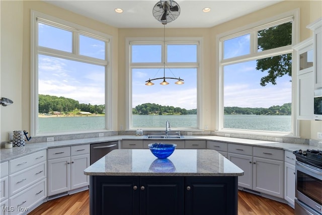 30 E Mohawk Dr, Malvern, OH 44644 - kitchen with stainless steel appliances, a kitchen island, light stone countertops, wood finished floors, and recessed lighting