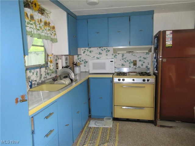 4455 Buck Run, Linesville, PA 16424 - kitchen with freestanding refrigerator, white microwave, blue cabinets, and exhaust hood