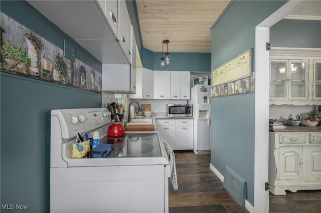 815 N Walnut St, Dover, OH 44622 - kitchen with white appliances, dark wood-type flooring, backsplash, white cabinets, and hanging light fixtures