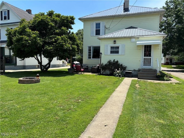 815 N Walnut St, Dover, OH 44622 - rear view of house with a metal roof, a yard, and a fire pit