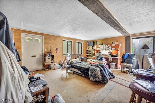 552 Turney Rd Unit A, Bedford, OH 44146 - bedroom with concrete flooring, a textured ceiling, and wooden walls