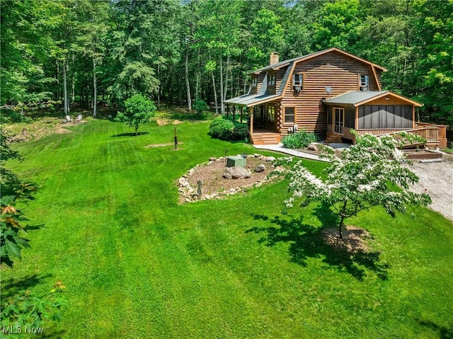 15961 Terramont St NE, Minerva, OH 44657 - view of green lawn featuring a sunroom, a forest view, gravel driveway, and a deck